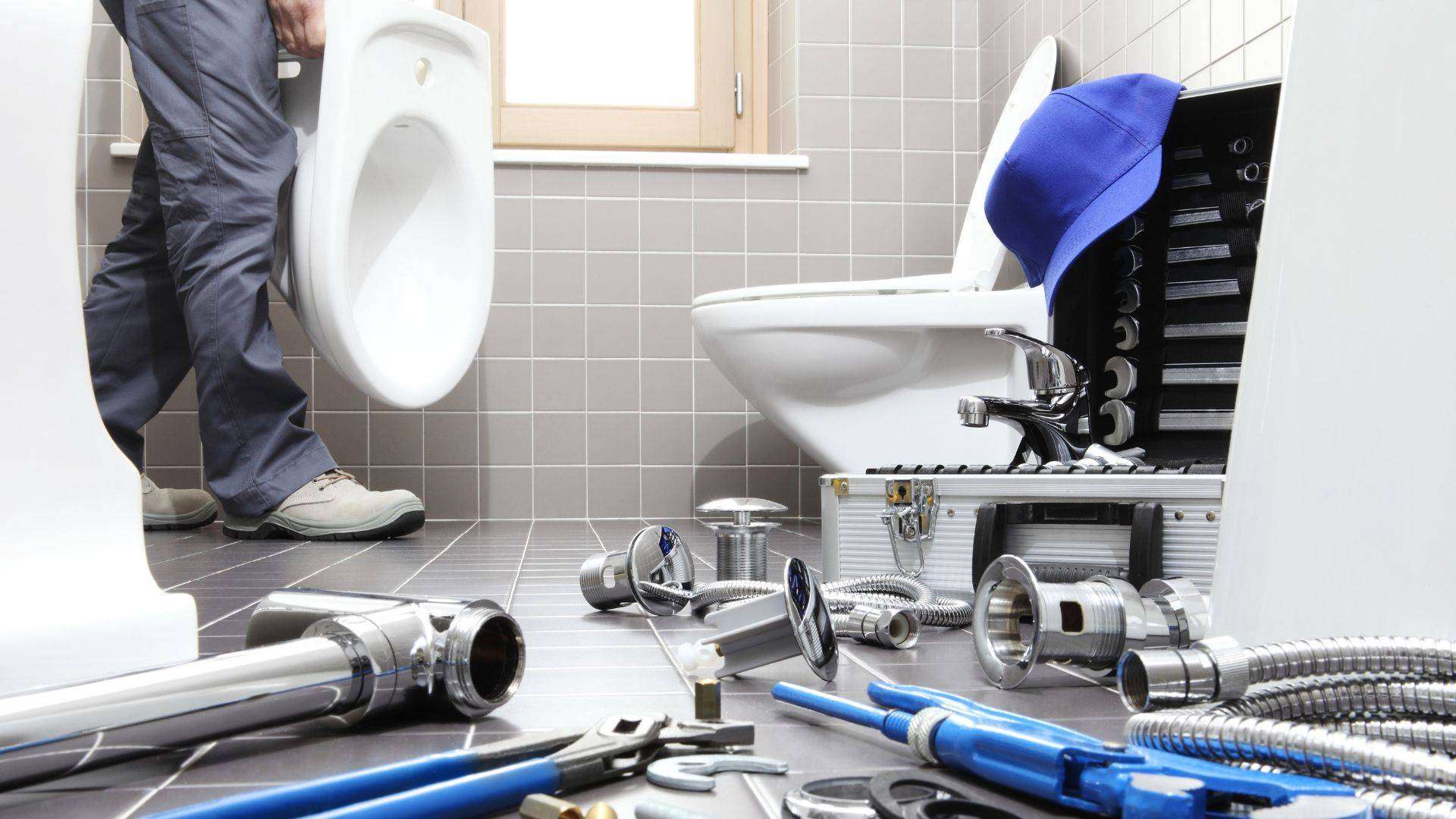 Image of a plumber in Denver repairing a toilet