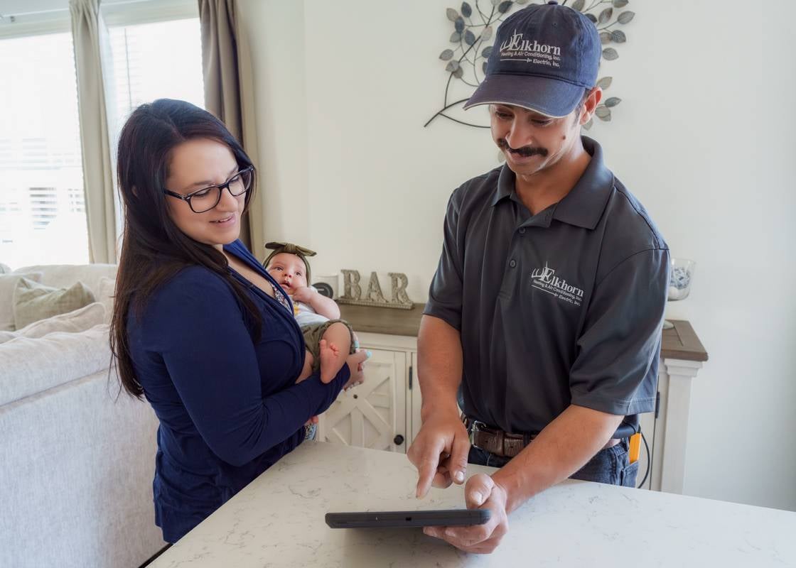 Elkhorn technician educating the homeowner about their HVAC equipment in Colorado.