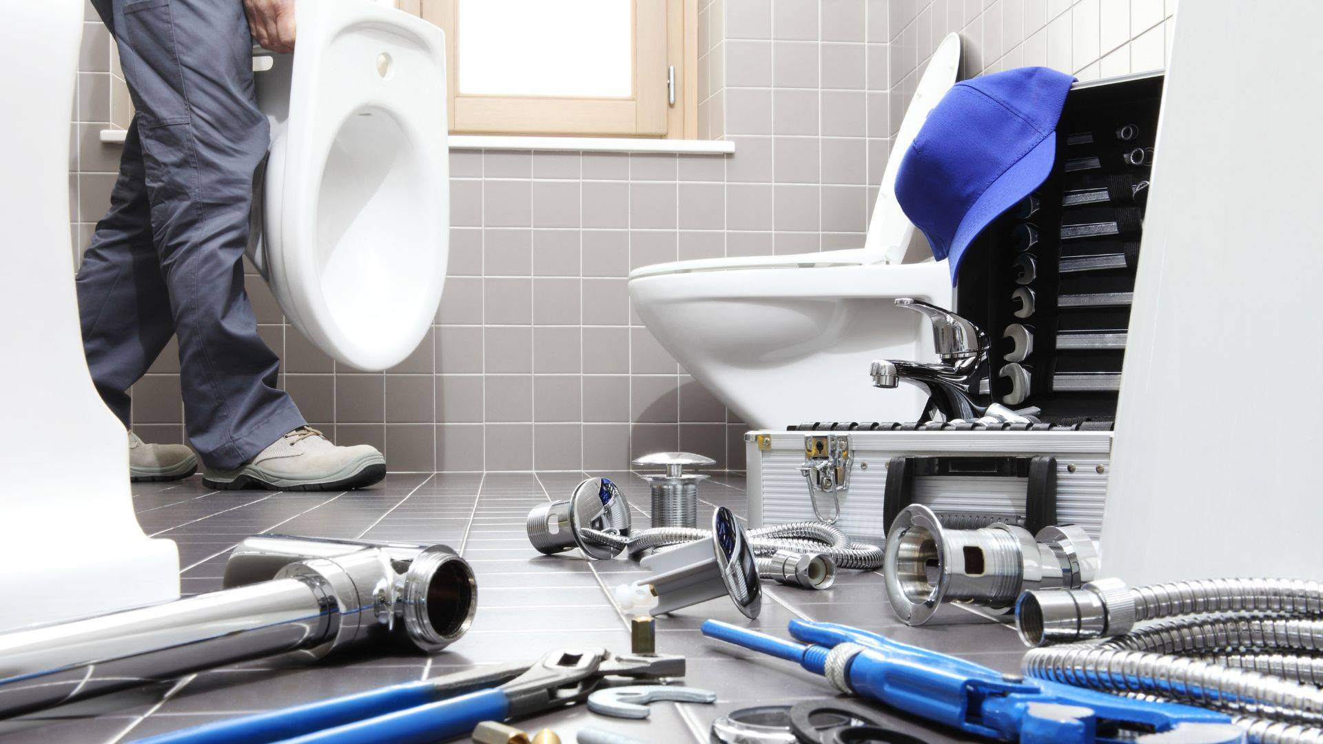 Image of a plumber in Denver repairing a toilet