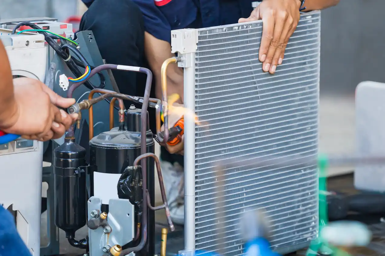 Technician repairing an AC condenser in Denver home.
