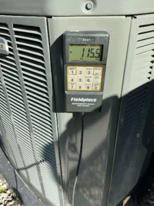 Denver AC service technician adding refrigerant and installing an indoor air quality upgrade.