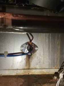 Furnace limit switch and attached wires mounted on a metal panel during service in Denver.