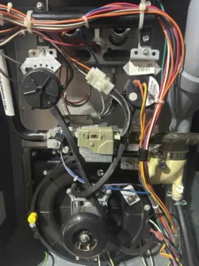 Furnace gas valve and wiring inside an open furnace cabinet during service in Littleton.