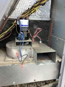 Inducer motor and fan housing inside a furnace cabinet during service in Littleton.