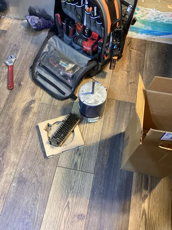 Motor beside a tool bag and service tools during a furnace noise diagnostic in Littleton.