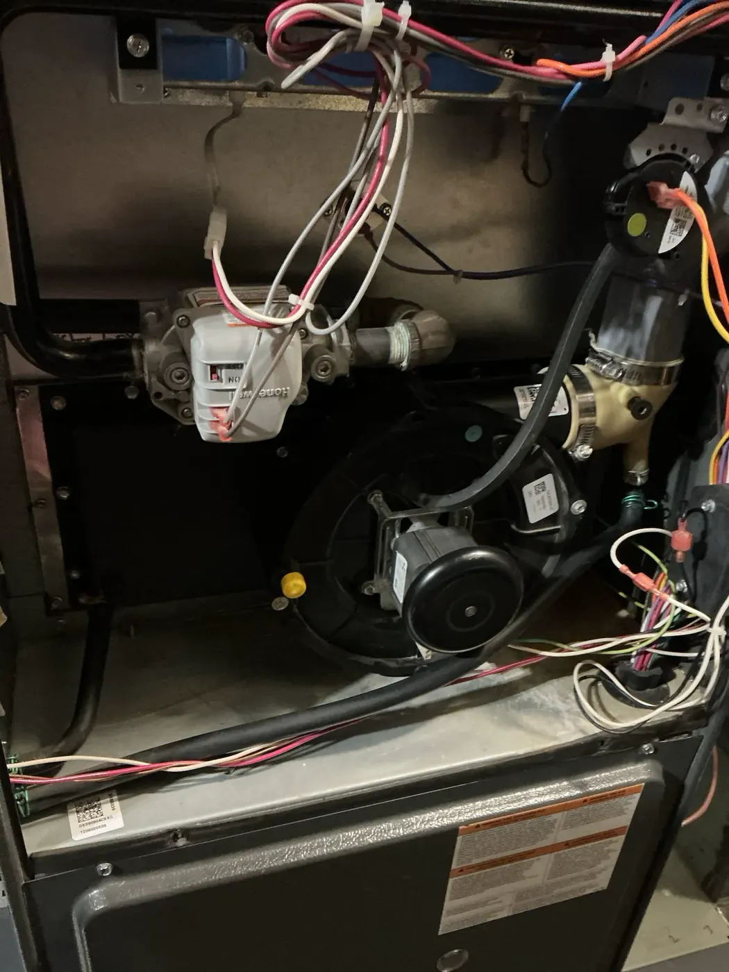 Open furnace cabinet showing the inducer assembly, gas valve, hoses, and wiring in Highlands Ranch.
