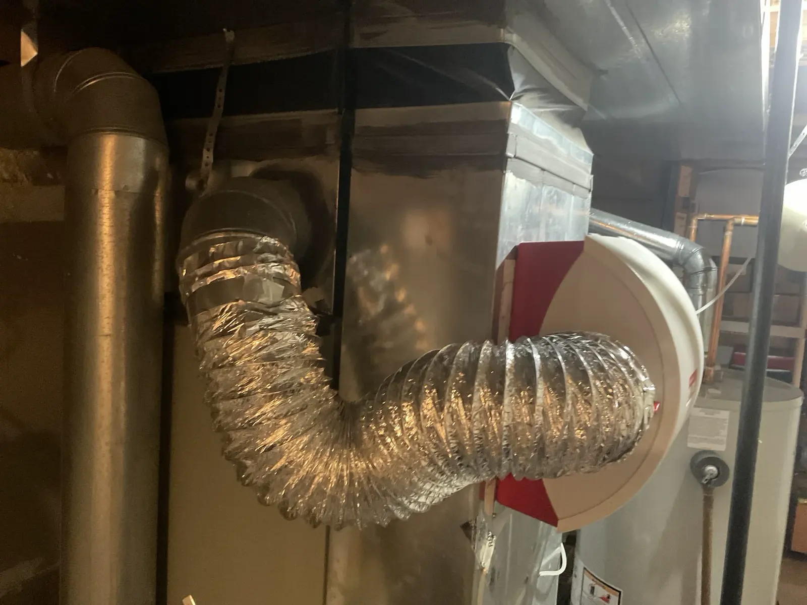 Duct-mounted humidifier and connected flexible duct at a Highlands Ranch home.